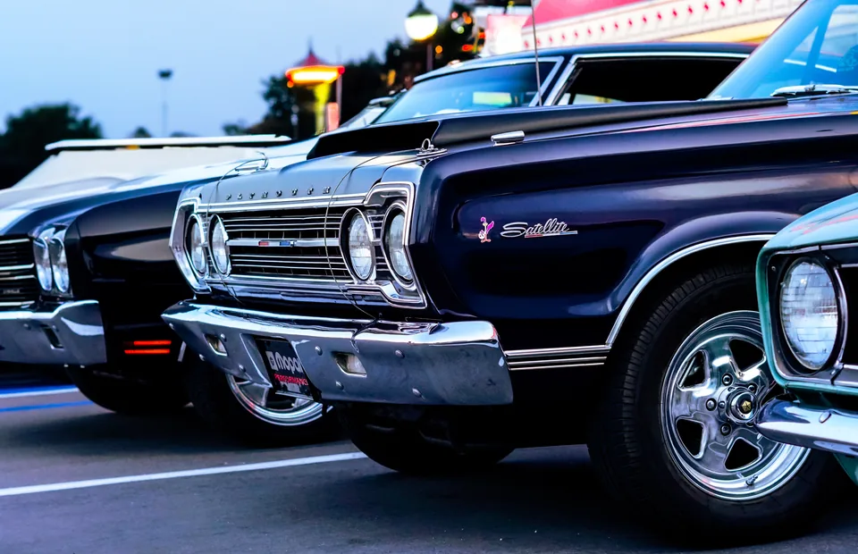 A purple vintage Impala at the front of a row of classic cars